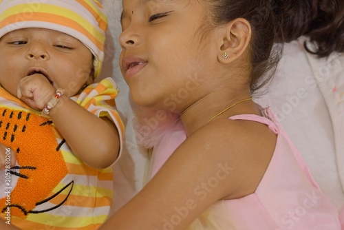 Young girl plays with baby sibling at home on a sunny day