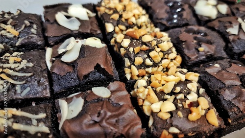 Assortment of chocolate brownies with various toppings nuts, chocolate chips and almond slices