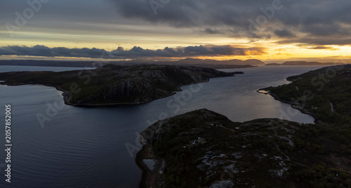 drone shot of midnight sun over Bokfjord near Ropelv in South Varanger, Northern Norway
