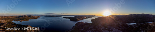 Panoramic drone shot of midnight sun over Bokfjord near Ropelv in South Varanger, Northern Norway