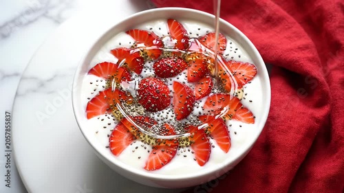 Yogurt bowl topped with strawberries and chia seeds.