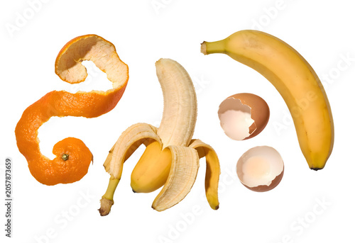 Fresh and Ripe Fruit and Snack Items Including Orange Peel, Banana, Banana Slices, Banana Peel, Whole Banana, Two Eggs with Shells, and Banana Skins Isolated on White Background