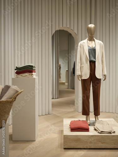 Luxury fashion retail store display with elegant mannequin wearing blazer and trousers mockup