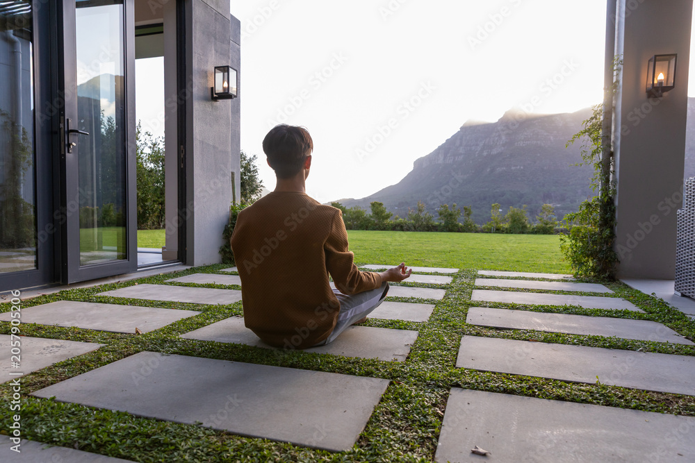 Fototapeta premium Concrete pavers forming grass grid on patio and leading toward sunlit mountain ridge
