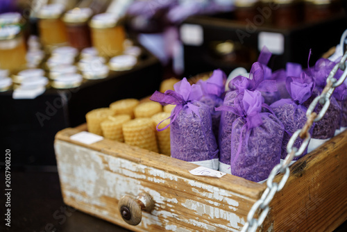 Cuadro en lienzo Rustic wooden box filled with dried lavender sachets and honeycomb candles at an outdoor market