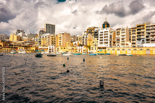 Bild auf Leinwand This image captures the picturesque Spinola Bay in Saint Julian's, Malta, featuring traditional colorful fishing boats