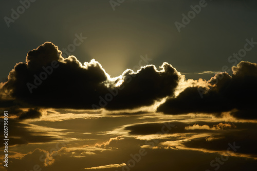 Quadro su tela massive dark clouds dramatically backlit by intense golden sunlight breaking through the cloud cover