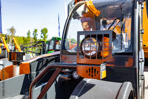 Obraz na plátně A construction worker wearing a hard hat and high-visibility vest sits in the cabin of an asphalt roller compacting freshly laid road surface