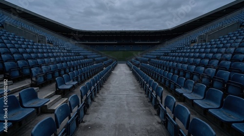 Empty blue stadium seating rows in dim light with modern architectural design