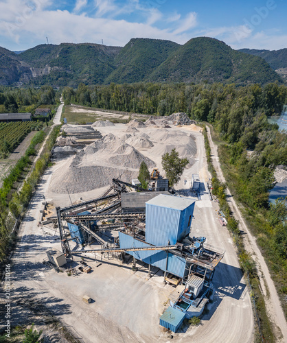 Aerial view of aggregate processing plant with conveyor systems, industrial machinery and mineral processing infrastructure operating within a quarry extraction site in Southern France