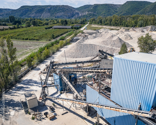 Aerial view of aggregate processing plant with conveyor systems, industrial machinery and mineral processing infrastructure operating within a quarry extraction site in Southern France