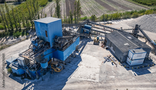 Close up aerial view of industrial aggregate processing facility and conveyor infrastructure in Southern France