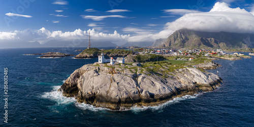 Fotografi Aerial rocky islet with white lighthouse and keeper's house near Henningsvaer, Lofoten, Norway