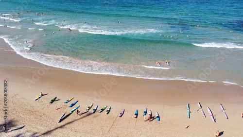 Photography Australian surf life savers training next to tourists on a beach in summer