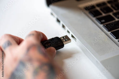 Bild auf Leinwand Hand inserting USB drive laptop