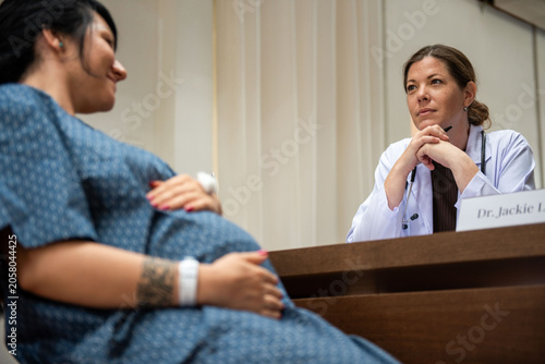 Tableau sur toile Pregnant woman consulting attentive doctor