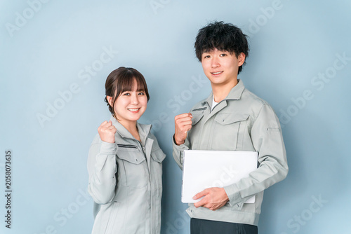 Konstfotografi ガッツポーズする作業着を着たブルーカラーの男女スタッフ