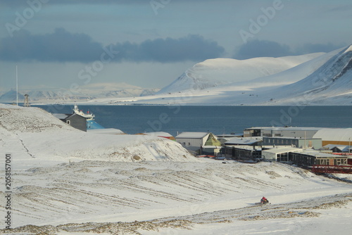 Longyearbyen town panorama in Svalbard, Norway. Remote arctic settlement with colorful houses, traditional wooden architecture, industrial heritage under winter snow and majestic polar mountains.