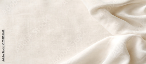 White linen fabric background with soft drapery folds and natural textile texture.