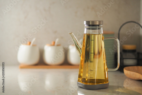 Tableau sur toile Glass kettle with tea on kitchen counter by white dishes