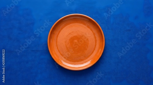 Empty Orange Plate on Bright Blue Background