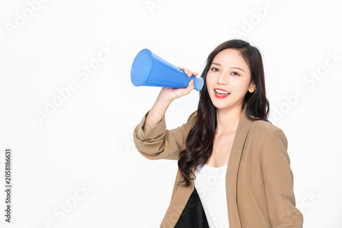 Canvas Print Smiling young woman speaking through blue megaphone on white background