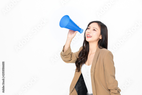 Konstfotografi Smiling young woman speaking through blue megaphone on white background