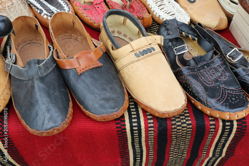Obraz na płótnie Traditional Serbian leather footwear opanci on a display market stall, various handmade Balkan peasant shoes