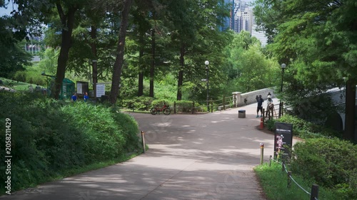 Peaceful afternoon landscape in Seoul Olympic Park, South Korea, featuring a lush green walking path and a bridge