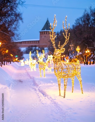 A snowy street with illuminated reindeer decorations at dusk
