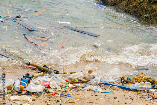 Foto Polluted beach with plastic waste and garbage washed up on the shore, environmen