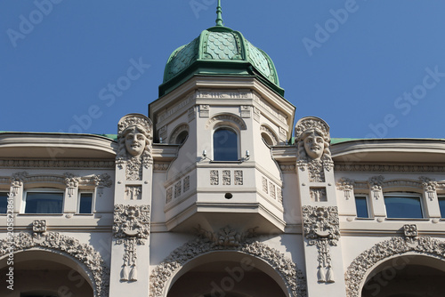 Fotografie Art Nouveau building facade with decorative sculptures and green dome in Belgrade