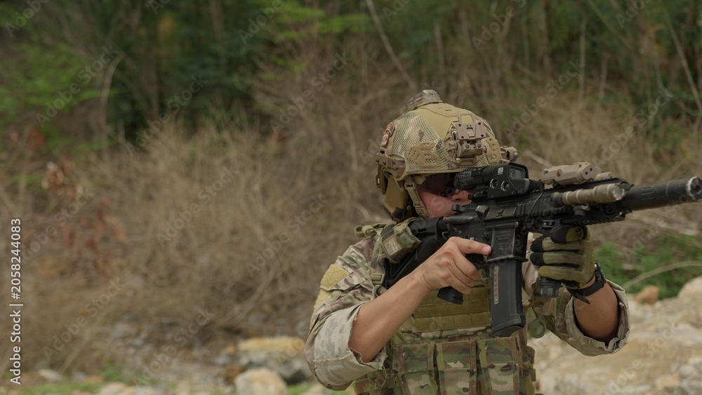 Fototapeta premium A special forces soldier aims his rifle during a tactical training exercise in a rugged outdoor environment, demonstrating precision and combat readiness.