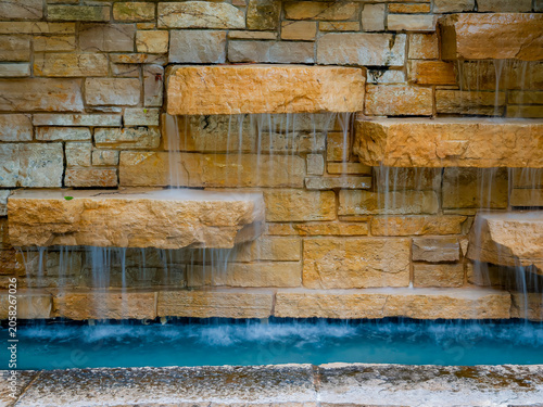 Bild auf Leinwand Modern outdoor stone brick wall water feature with cascading tiered waterfalls f