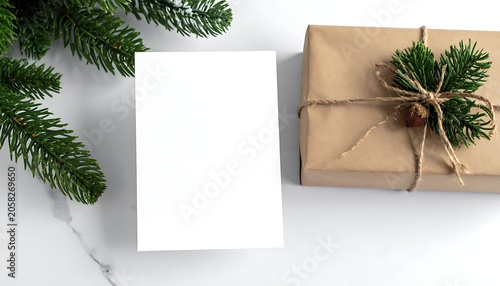 Festive setup featuring gift, pine branches and a blank card on marble table, perfect for winter holiday themes