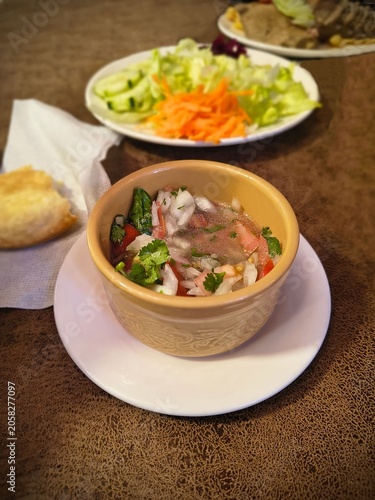 Close-up of traditional Chilean pebre sauce served in a ceramic bowl at a restaurant