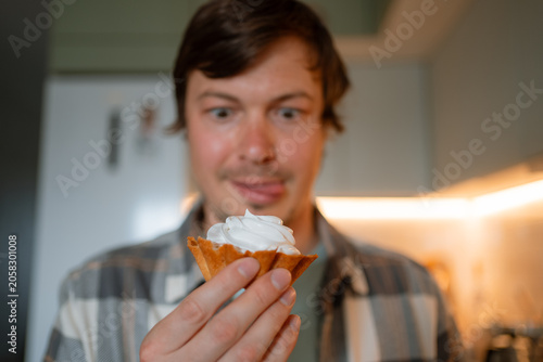 Fotografie Man excitedly looking at a cupcake, showing strong sugar craving and a sweet too