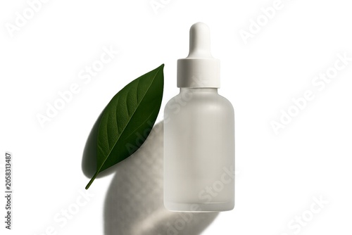 Frosted matte glass serum dropper bottle with green leaf on white