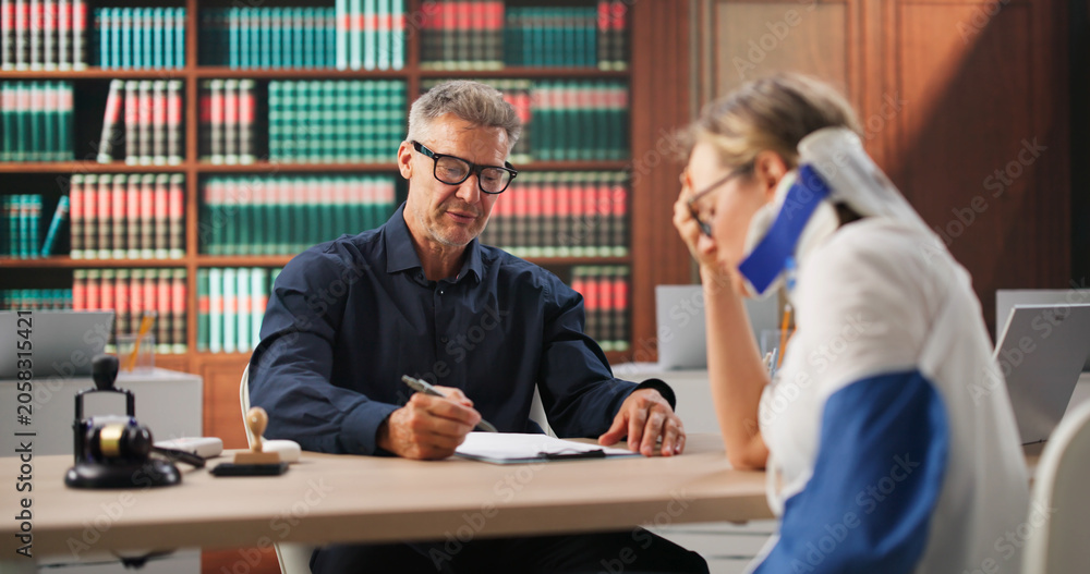 Fototapeta premium Injured Worker Discusses Compensation Claim With Her Lawyer