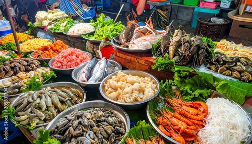 A vibrant display of fresh seafood and vegetables on a market stall