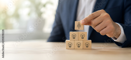 Idea creation and innovative product launching concept. Wooden block with rocket and idea generation icons. Idea creation, innovation and the launch of a new product from concept to execution.