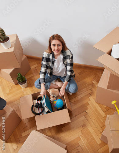 Woman unpacking personal belongings from moving box