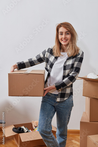 Woman carrying packed box while unpacking belongings