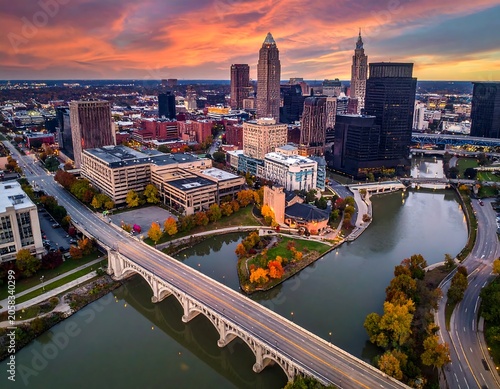 Aerial view of a city with a bridge over a river at sunset