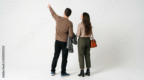 young couple looking up at something man pointing upwards