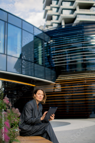 Woman using tablet while si...