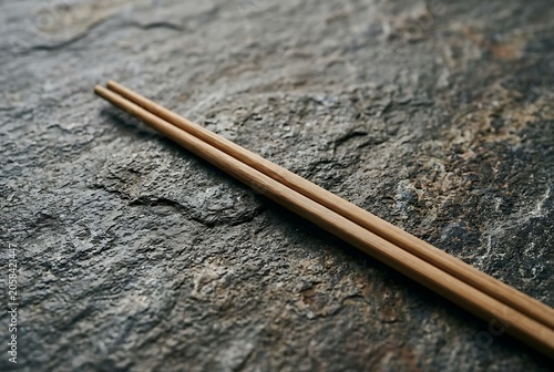 Wooden chopsticks on a textured dark stone surface