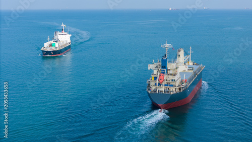 Foto Two large cargo ships navigating together through the deep blue ocean, representing a maritime transport fleet, global logistics network, and international shipping trade industry