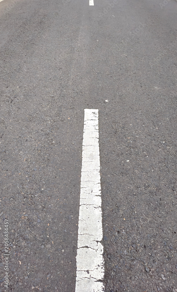 Fototapeta premium Dashed line markings on the road as a lane divider between two vehicle flows