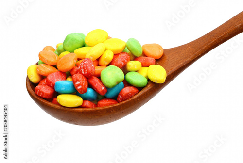 Bild auf Leinwand Wooden spoon filled with assorted colorful candy pebbles